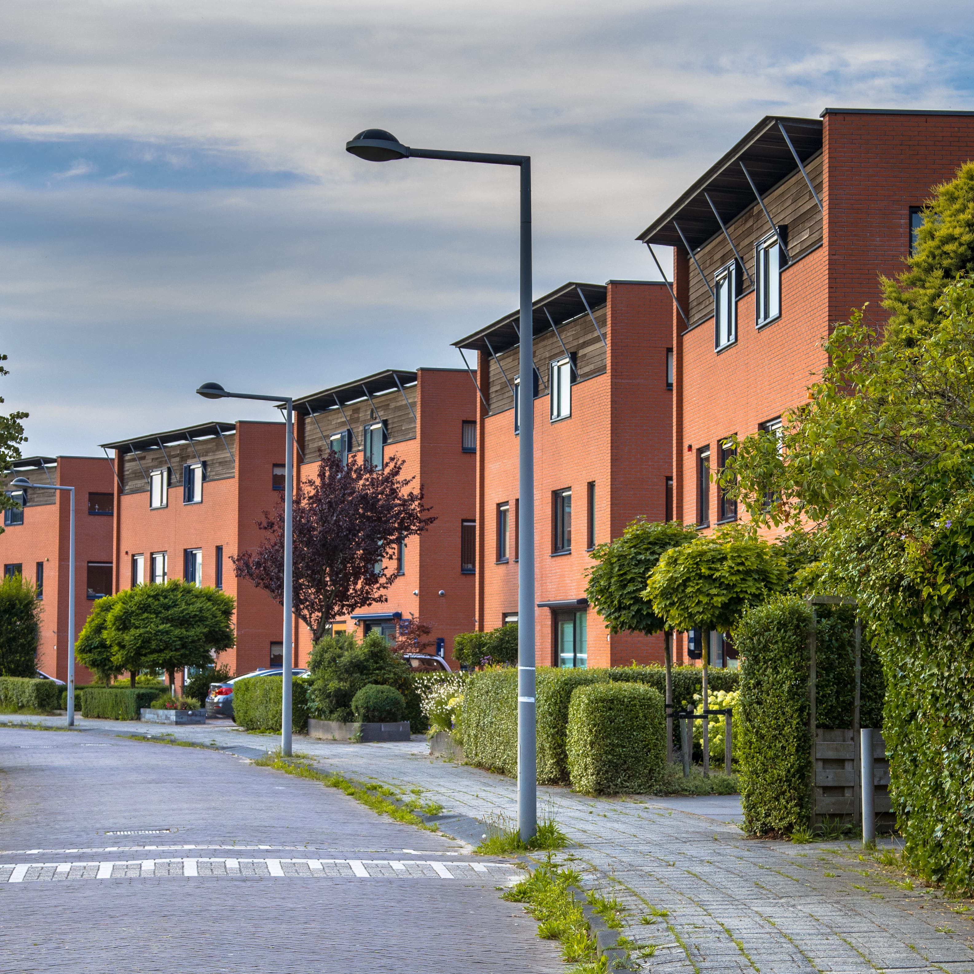 Quiet residential street lined with brick apartment buildings — real estate investment property