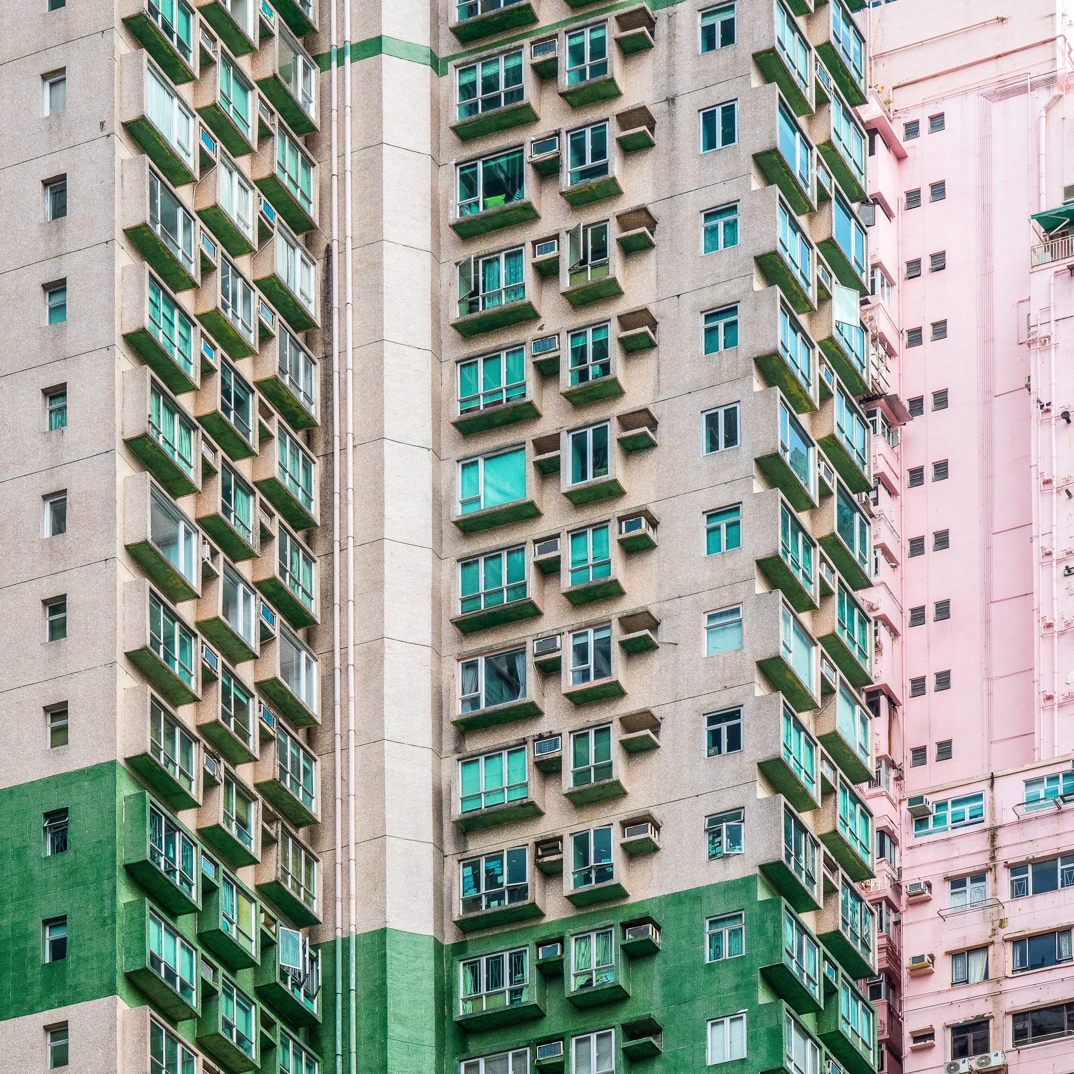 Green and pink high-rise apartment buildings in an urban setting — real estate investment property