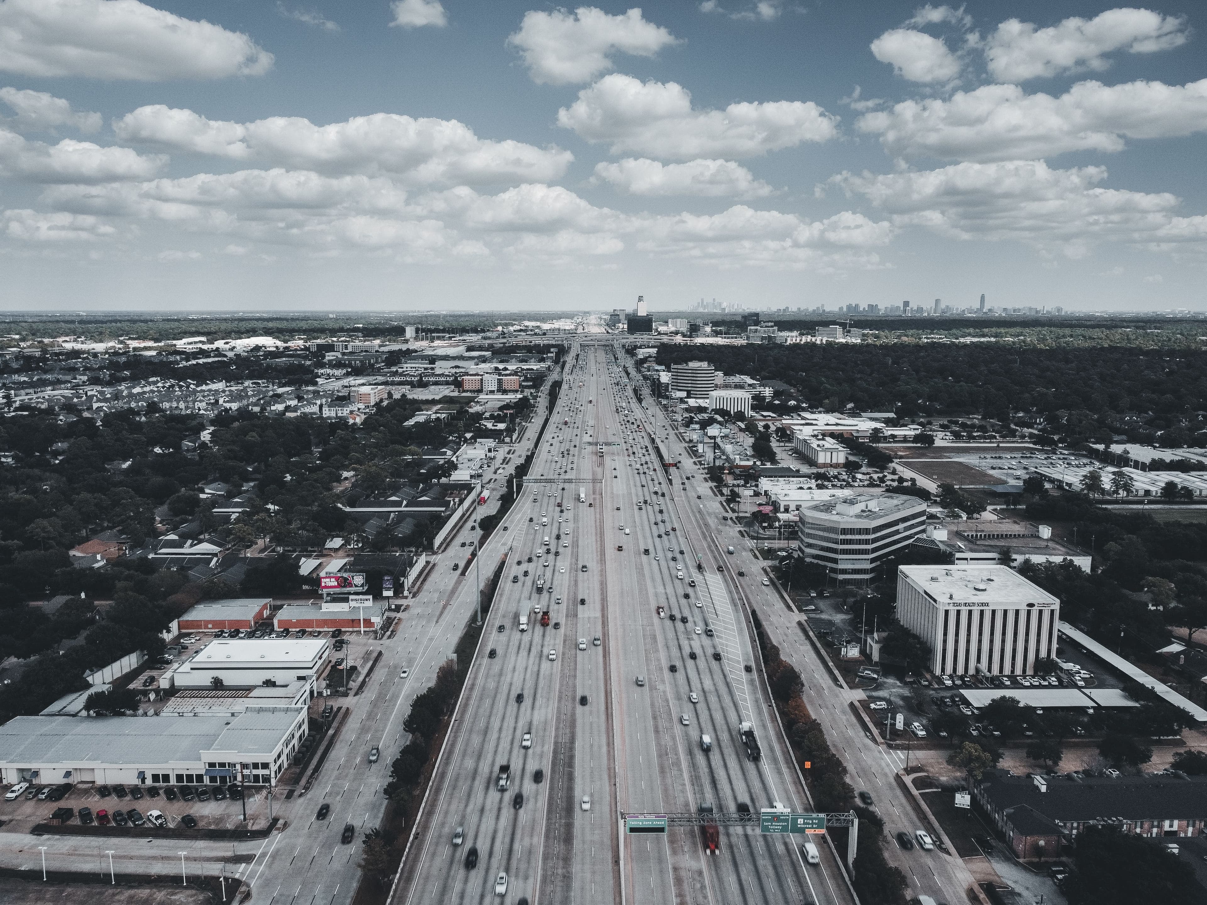 Aerial view of Houston, Texas highway approaching downtown skyline — real estate investment opportunities