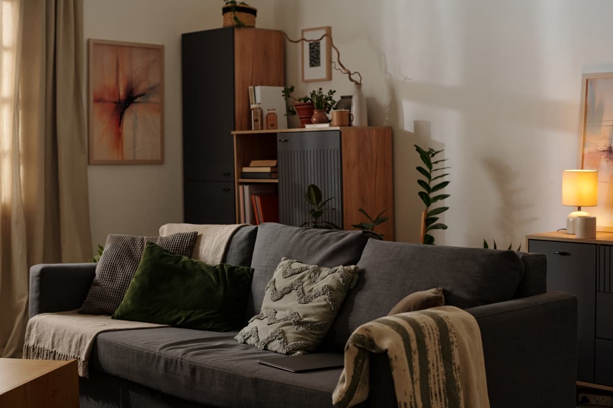 Well-furnished apartment living room with gray sofa, decorative pillows, and warm ambient lighting