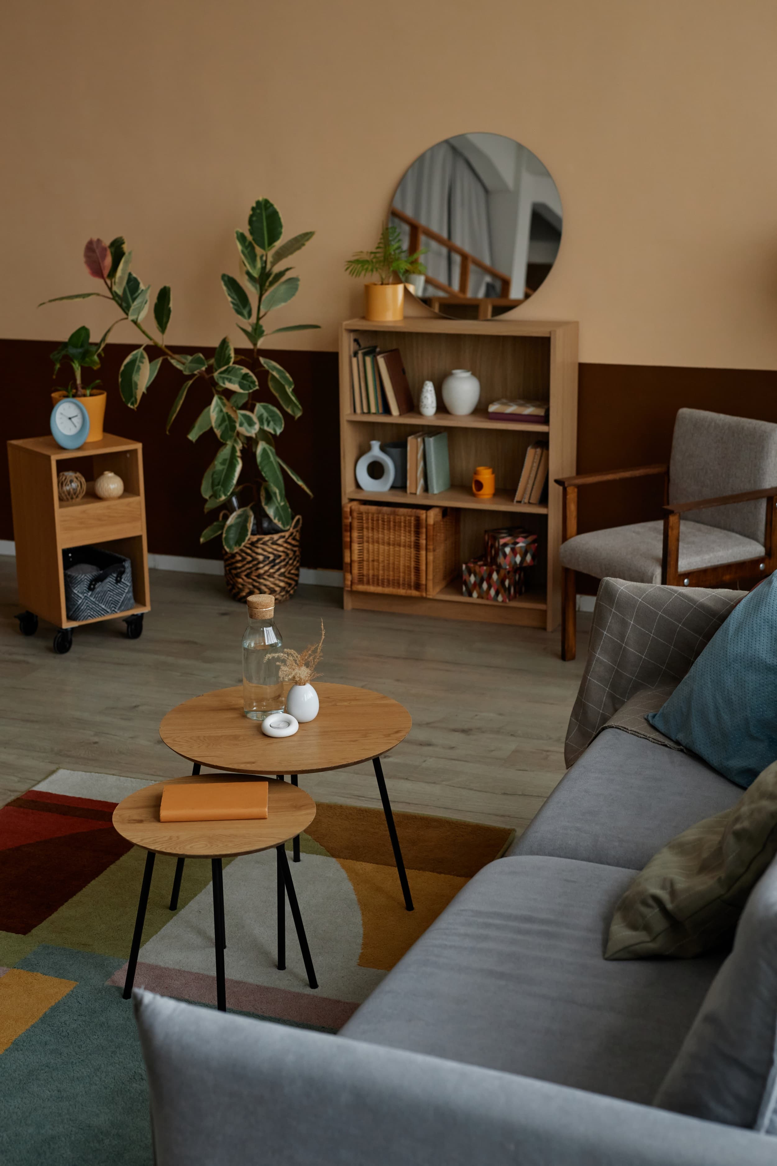 Stylishly furnished rental property living room with wooden furniture, houseplants, and a colorful area rug